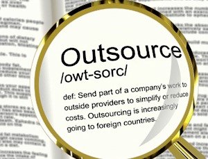 a golden magnifying lens on the word outsourcing