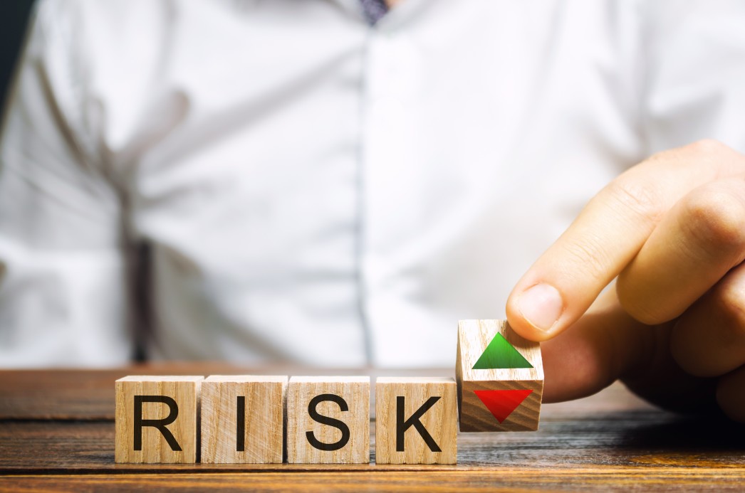 Risks written on wooden cubes for pros and cons of outsourcing