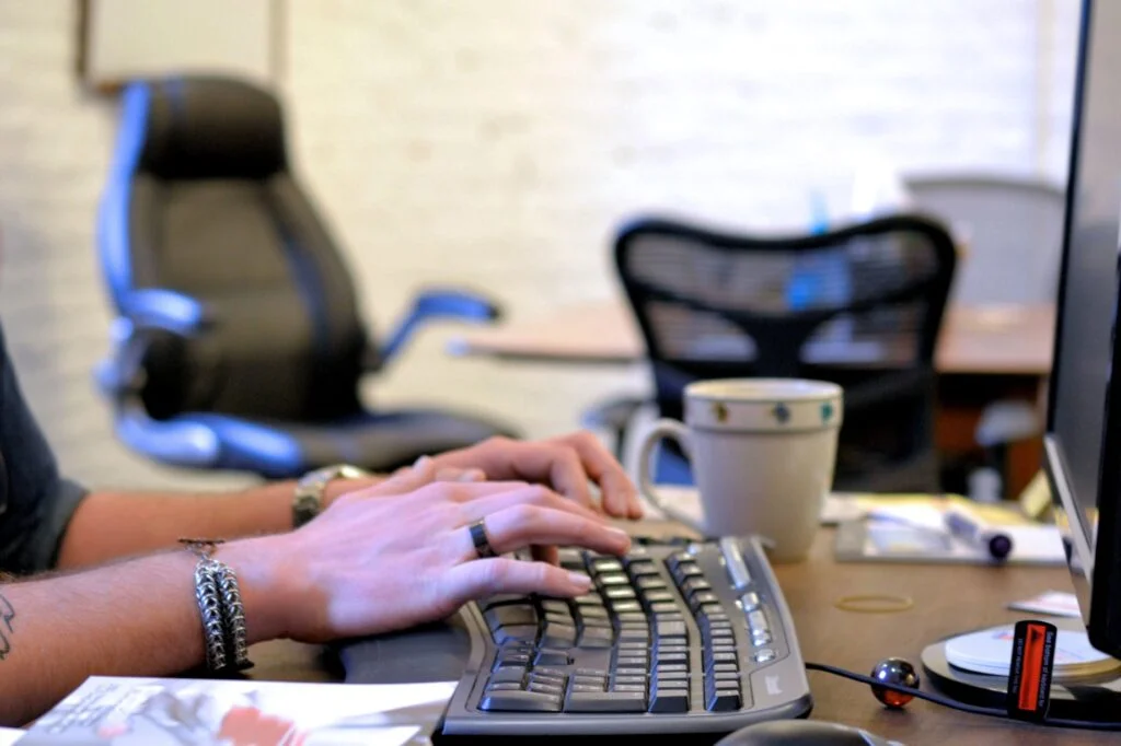 at the office typing on a keyboard for data entry e1635145858897