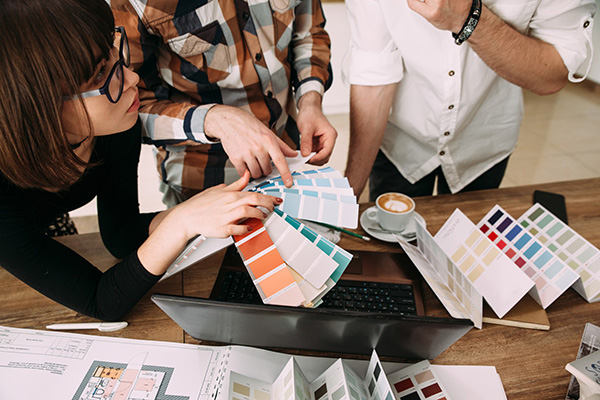 group of designers at workplace choosing colorful paper charts