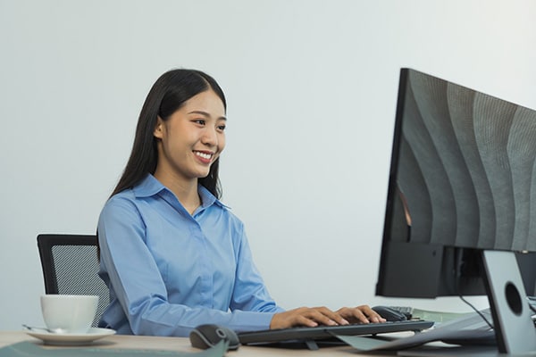 business woman working on desktop computer monitor professional and sitting at her office desk