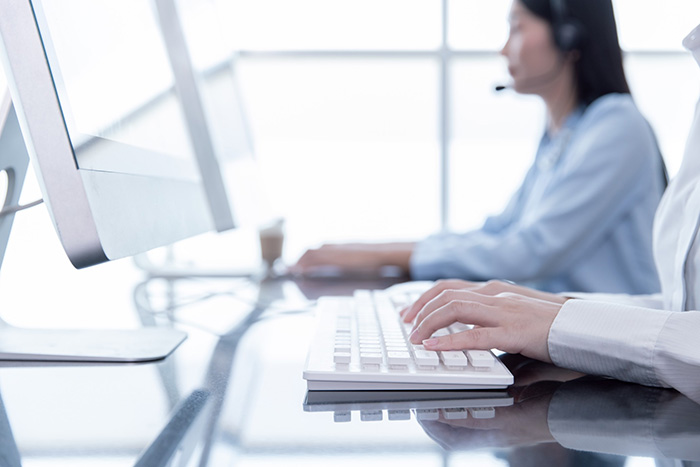 closeup hand officer typing record customer data in computer crm software people call center working