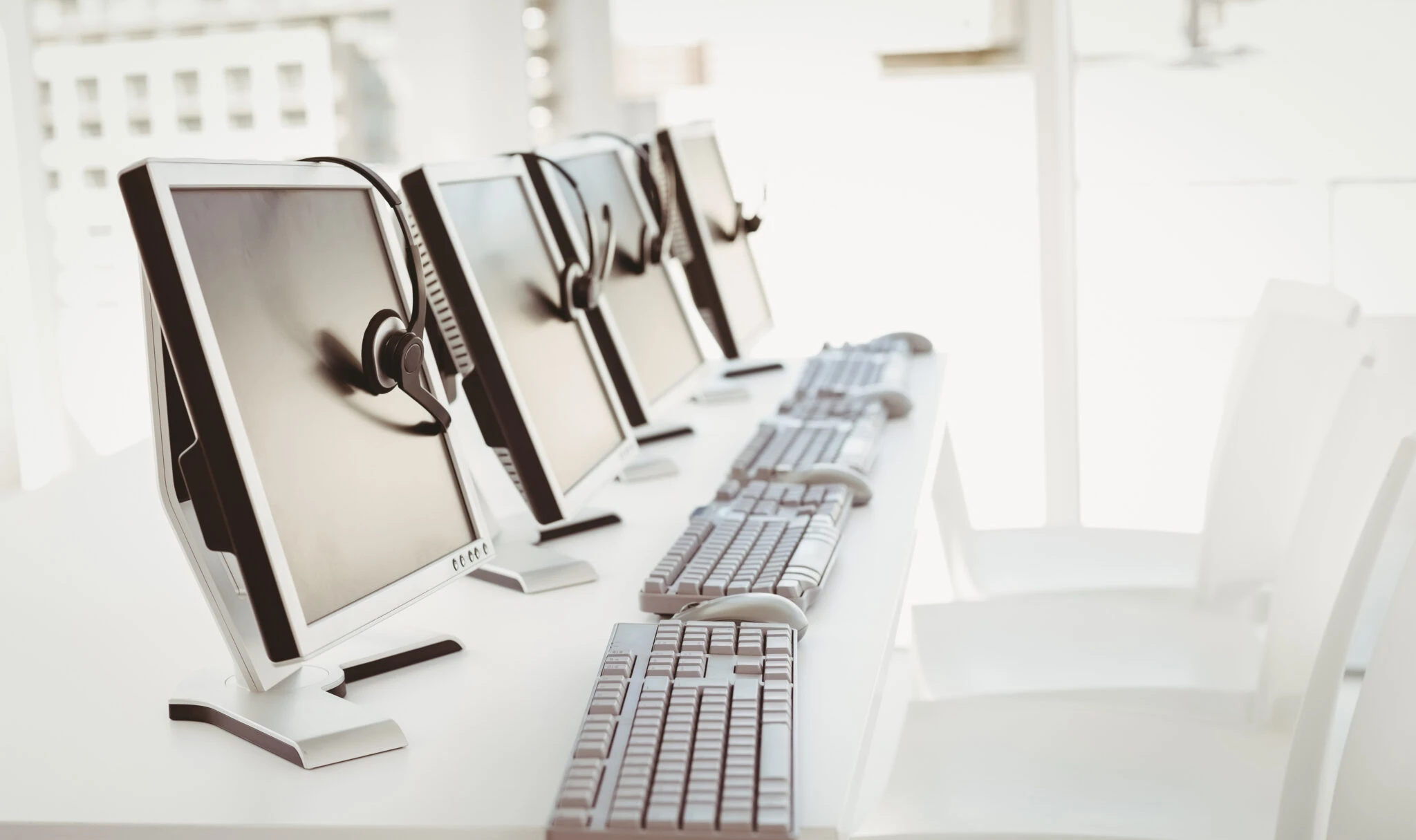 call center computers and headsets all in a row