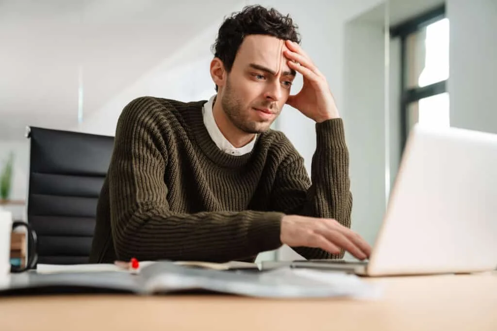 stressed software developer looking at laptop 1024x683 1