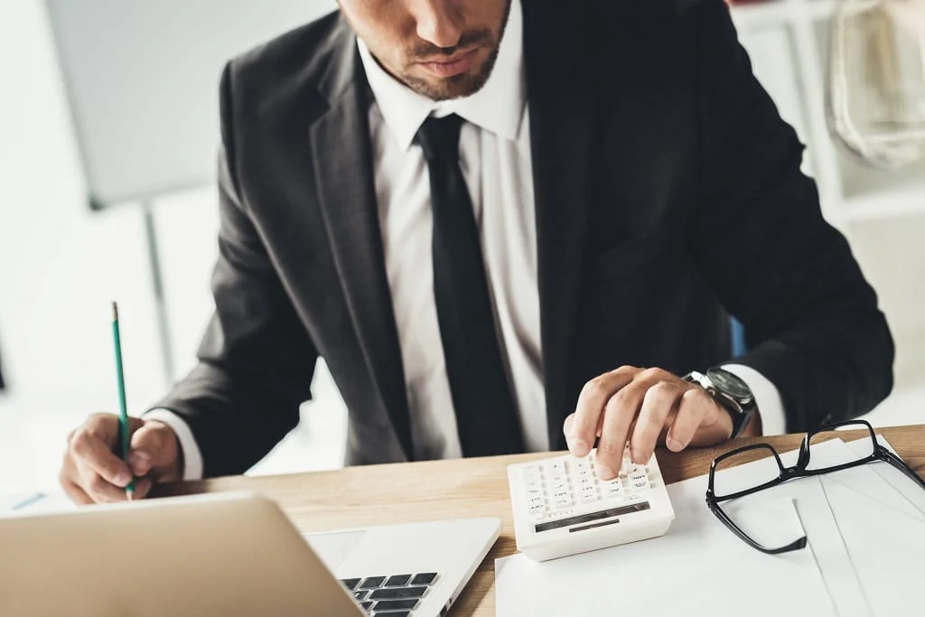 closeup photo of a payroll manager using a calculator