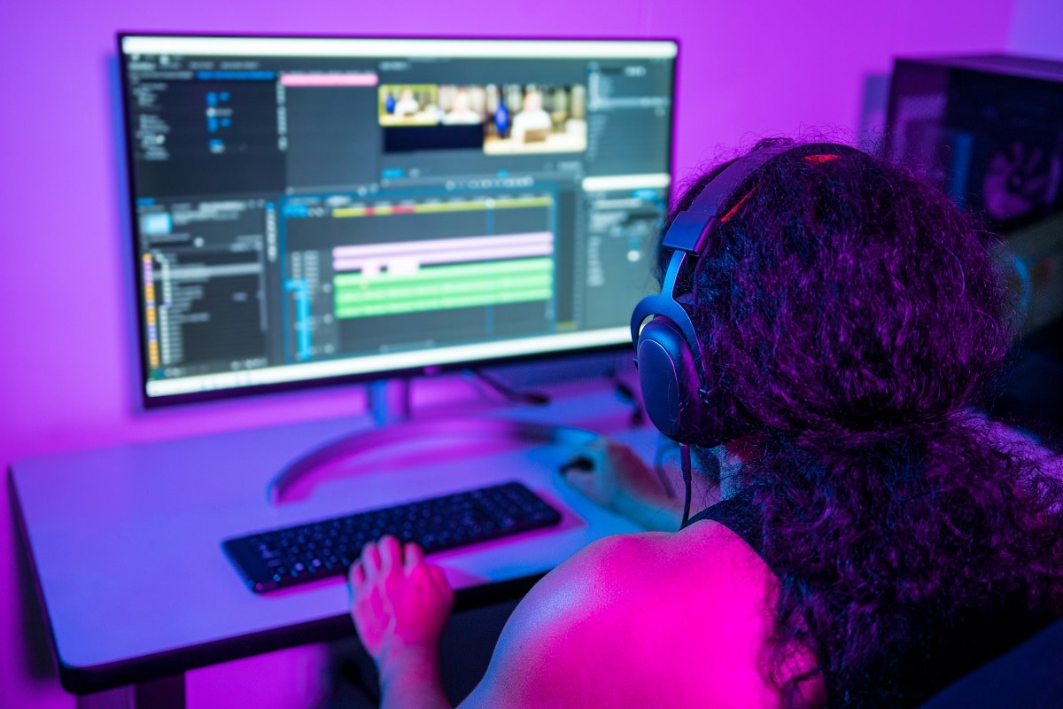 a focused female video editor meticulously fine-tuning video clips on her computer