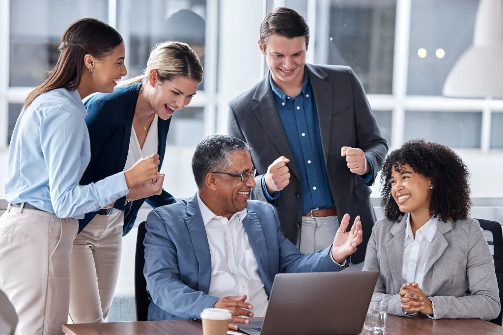 an executive smiling as he eagerly listens to the workplace concerns of his employees