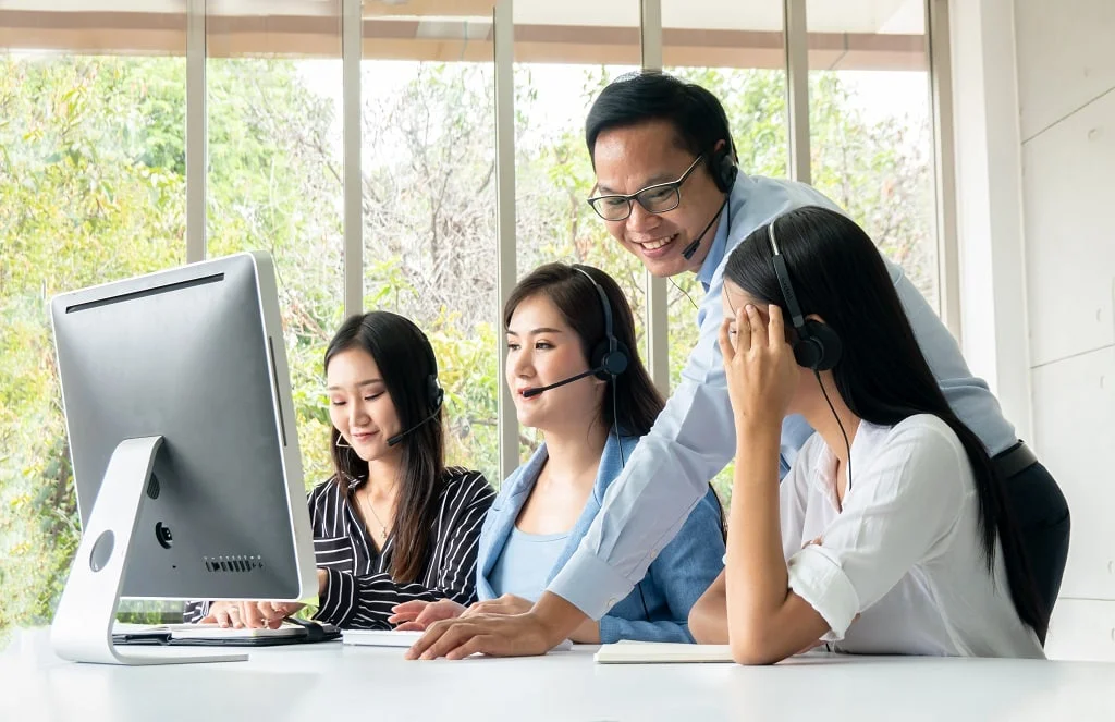 a group of Filipino customer service agents working together in a call center