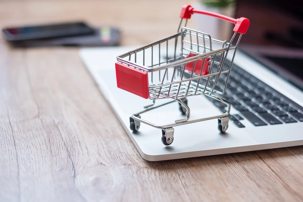 a miniature shopping cart on a laptop symbolizing the social retail concept