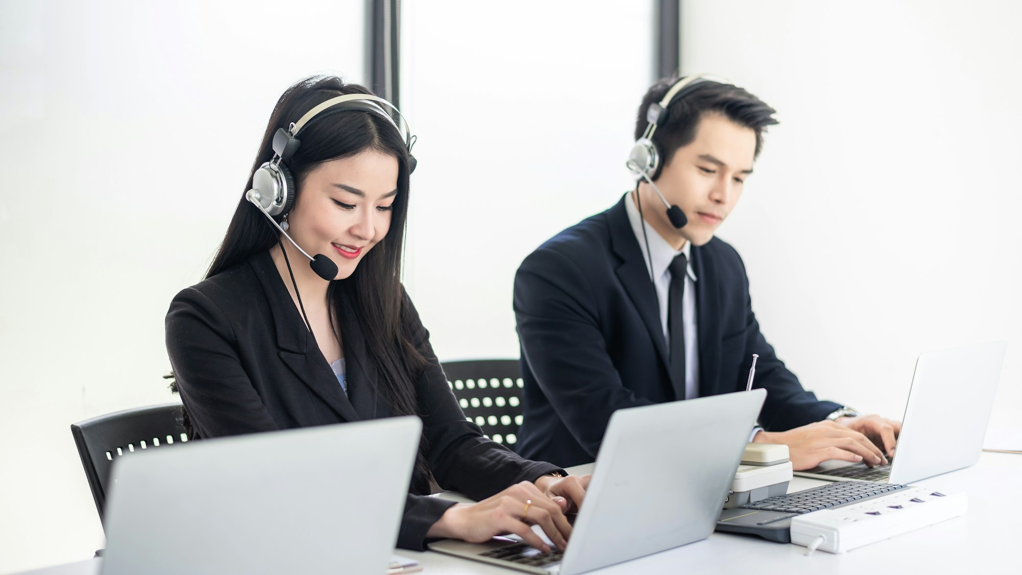 Customer service woman and man wearing a headphone to serve customers at the office