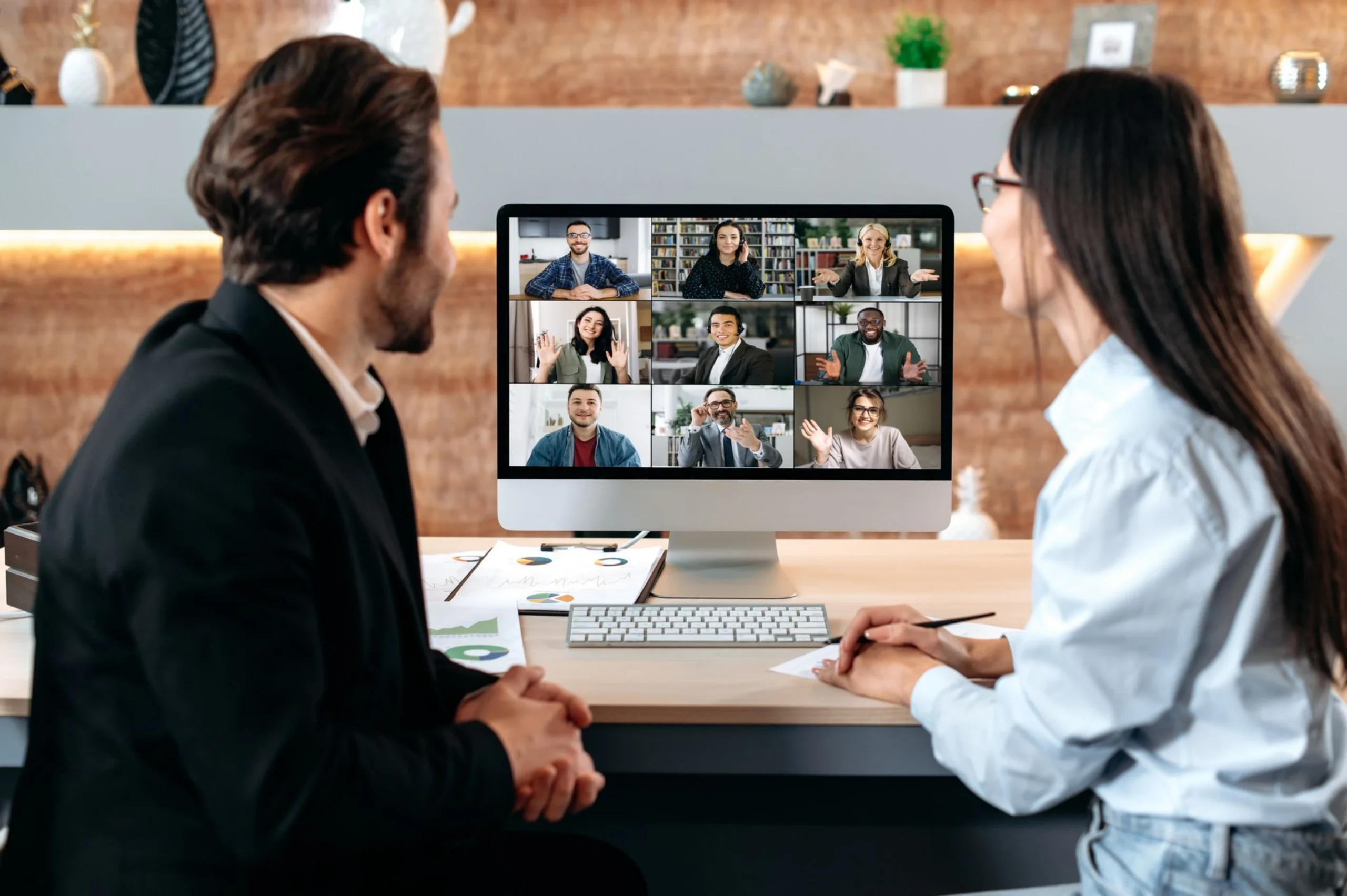 Two professionals engaged in a virtual meeting, discussing digital marketing strategies in front of a laptop.