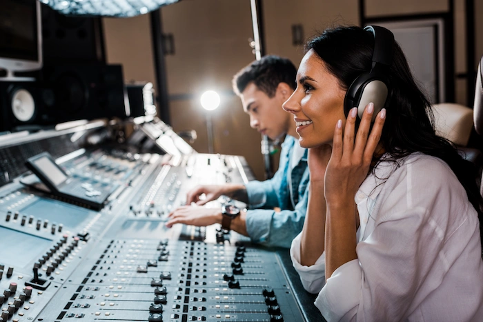 audio production editing smiling woman sitting in headphones in recording