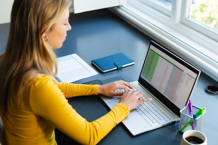 data entry focused woman sitting at desk encoding data