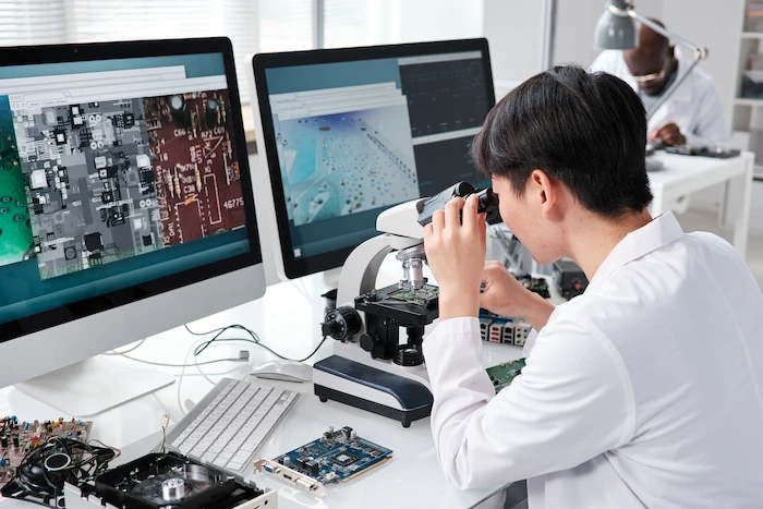 hardware support technician looking in microscope checking hardware