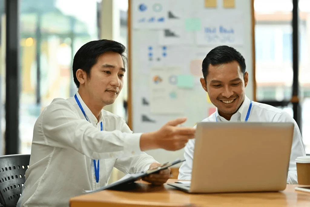 two employees helping each other to optimize outsource work in the philippines