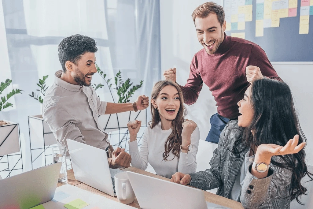 four employees celebrating the success of outsourcing back office