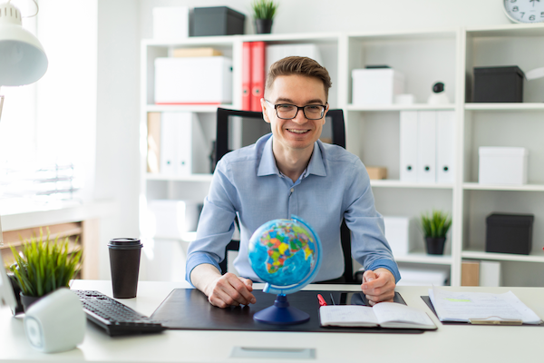 a young man sits in the office at a computer