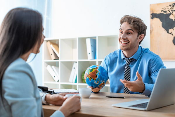 cheerful travel agent holding globe