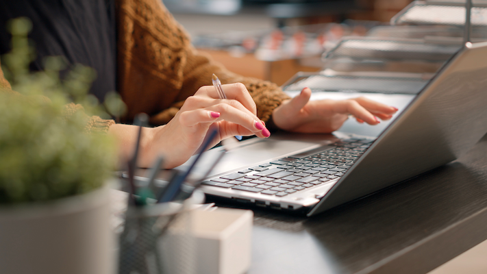 close up of woman typing on laptop