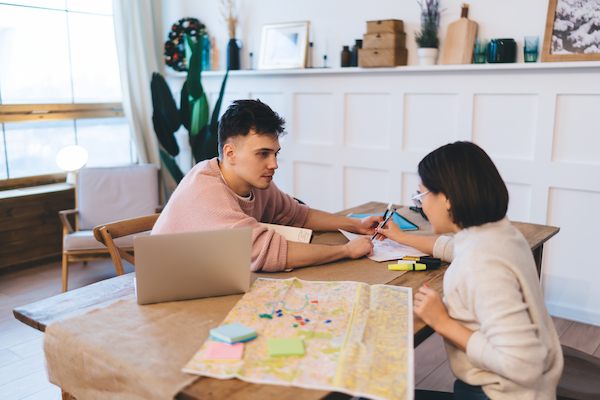 couple planning vacation or journey at table