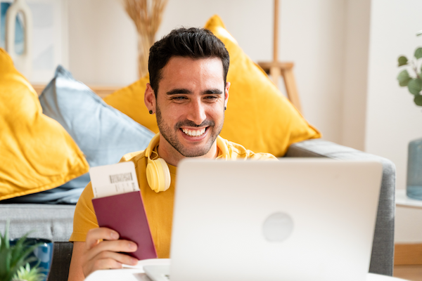 optimistic man holding plane ticket and passport