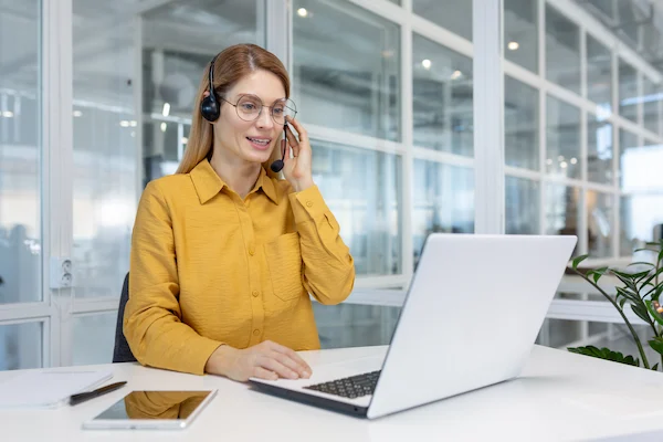 portrait of a young woman in a headset working e1728612670895