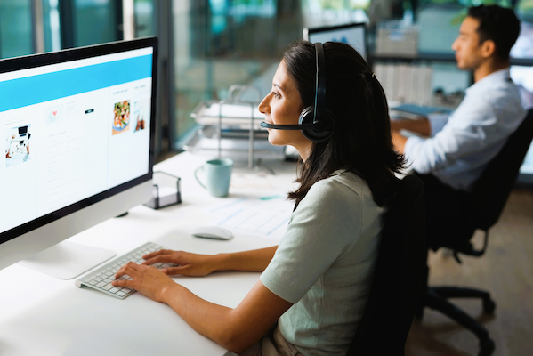 shot of a young woman using a headset and compute