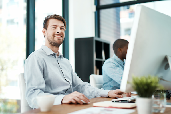 smiling eomployee while working on a computer