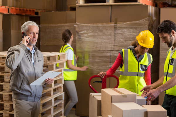 warehouse manager and workers preparing a shipment