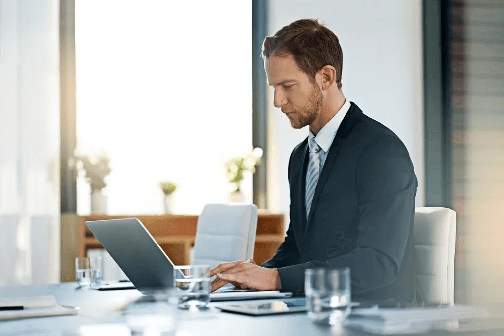 business owner researching office management outsourcing using his laptop