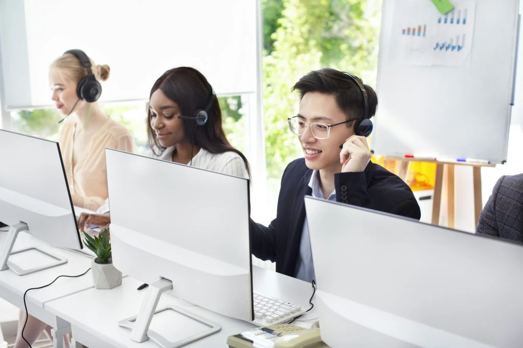 team of helpline operators with headsets consulting clients at call center 1024x682 1