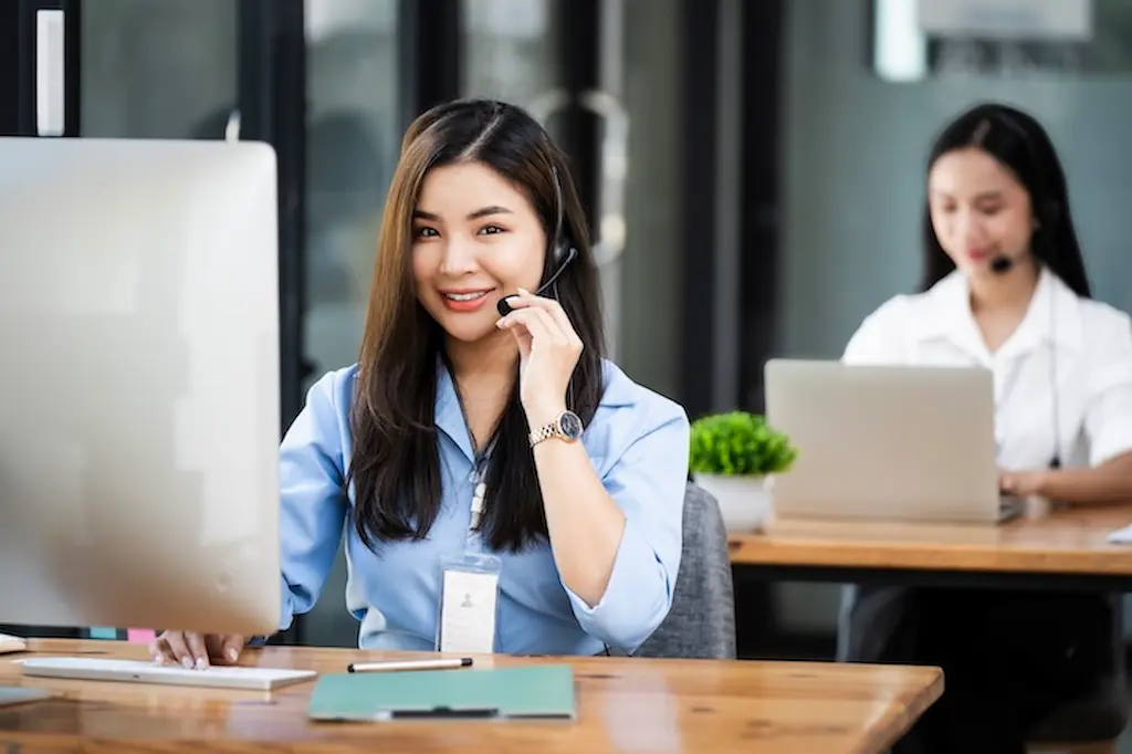 female call center agent with headset working on her desk