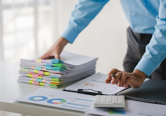 businessman working on stacks of documents in bookkeeping