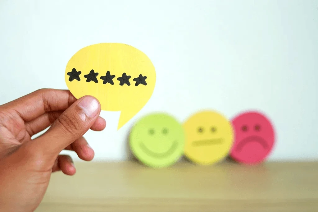 customer holding a five-star rating with emoticons as a backdrop