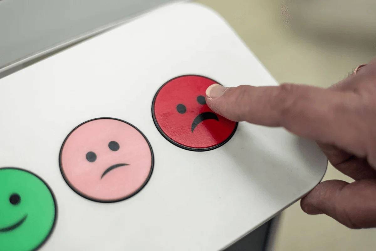 customer pressing red button with sad emoticon for negative feedback