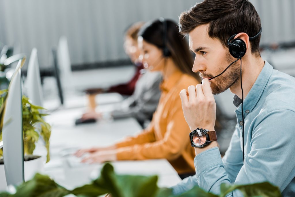 selective focus of call center operator in headset working in office