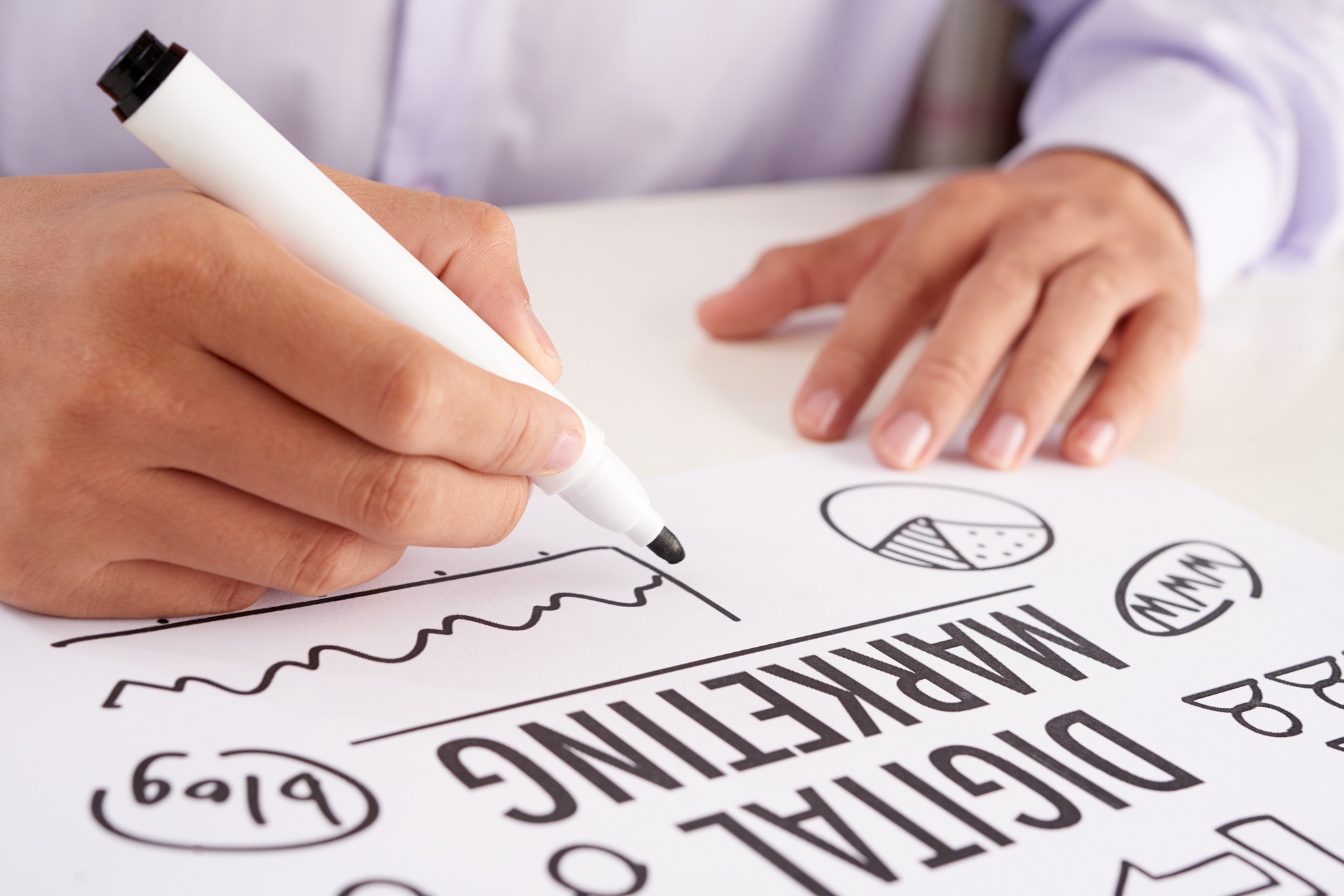 Crop hands making notes on digital marketing scheme