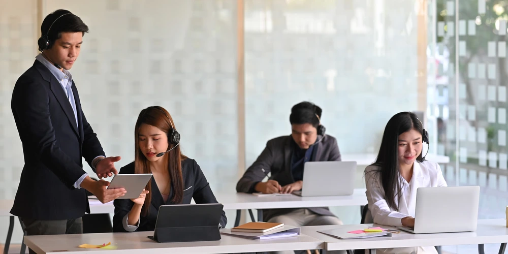A customer service manager providing training and coaching to an agent.