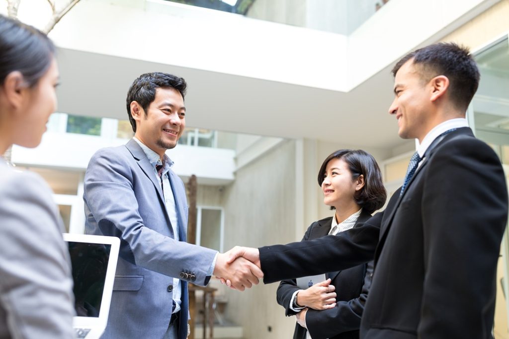 outsourcing partner and client shake hands showing happy relationship related to friendshoring