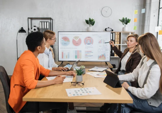 Four-Female-Partners-Sitting-At-Desk-And-Discussing four female partners sitting at desk and discussing
